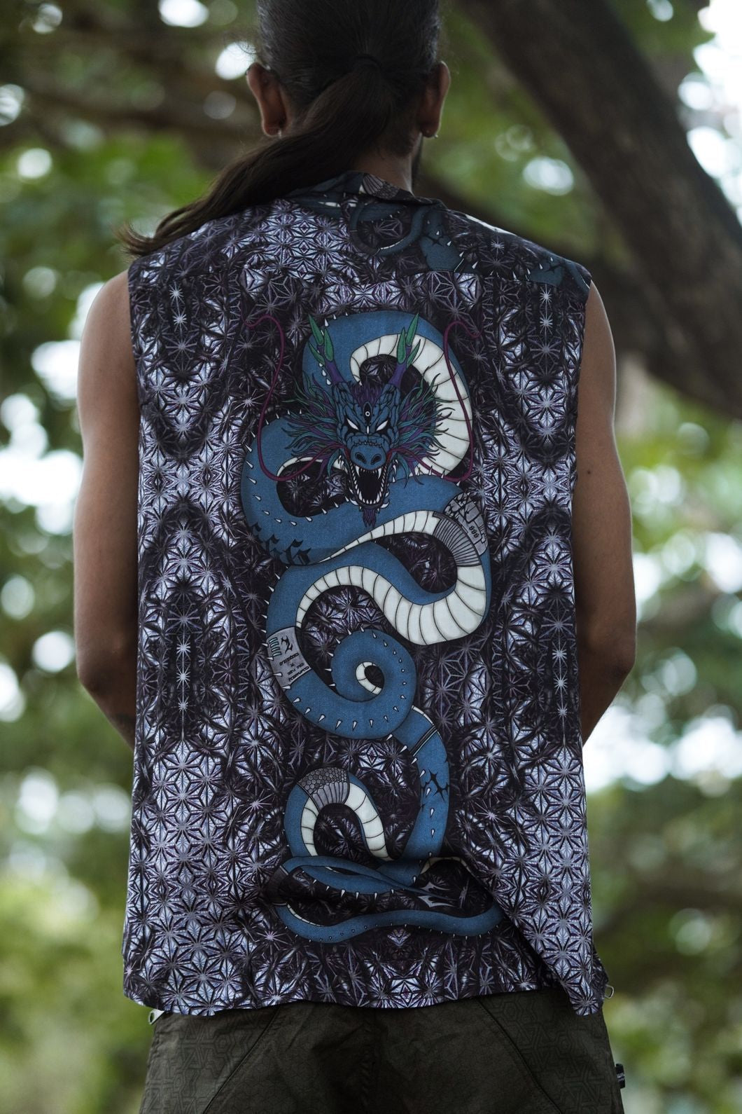 Back view of men’s bamboo sleeveless shirt with large psychedelic serpent artwork and geometric pattern design
