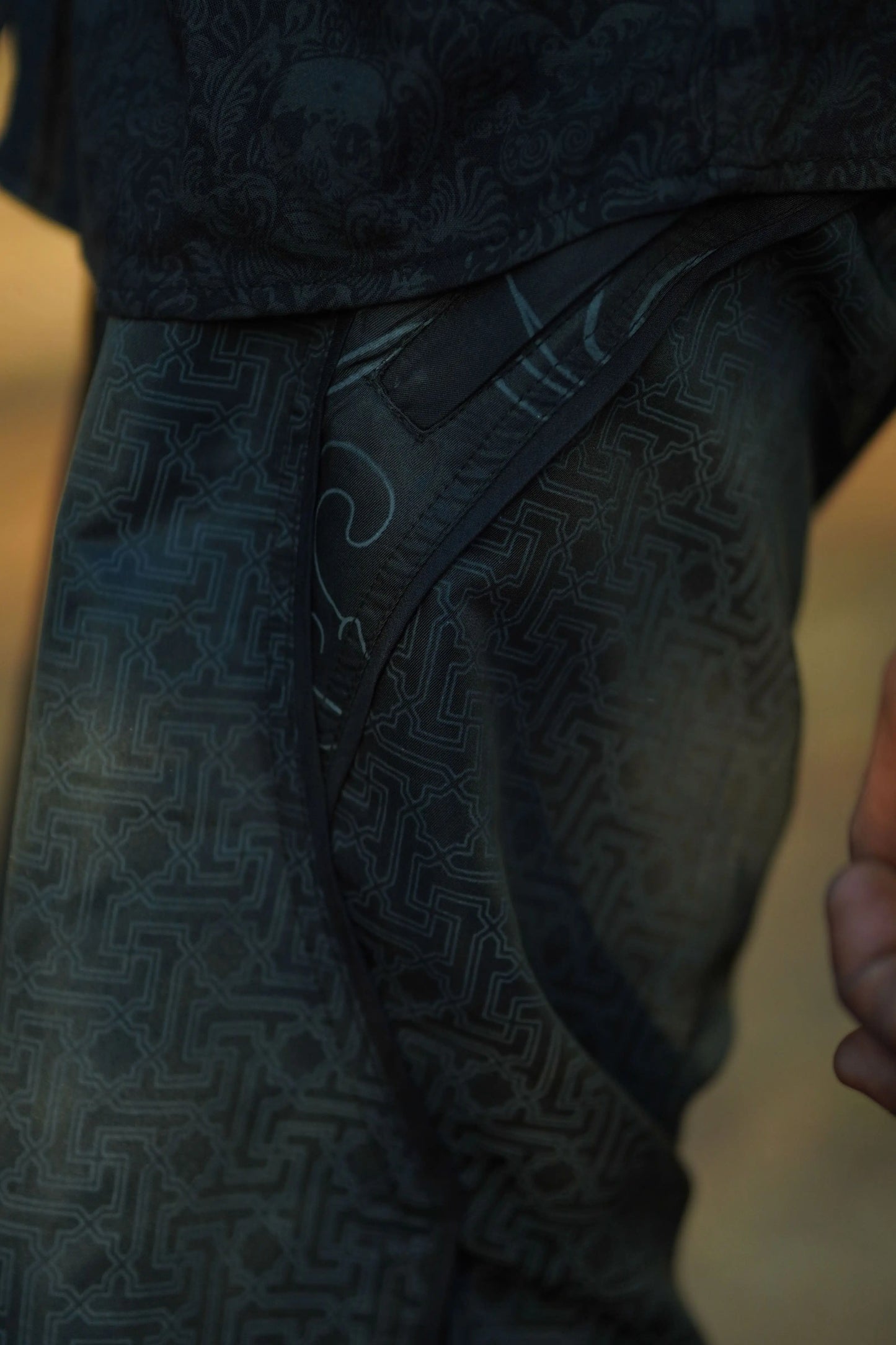 black festival swim shorts with geometric pattern pocket detail